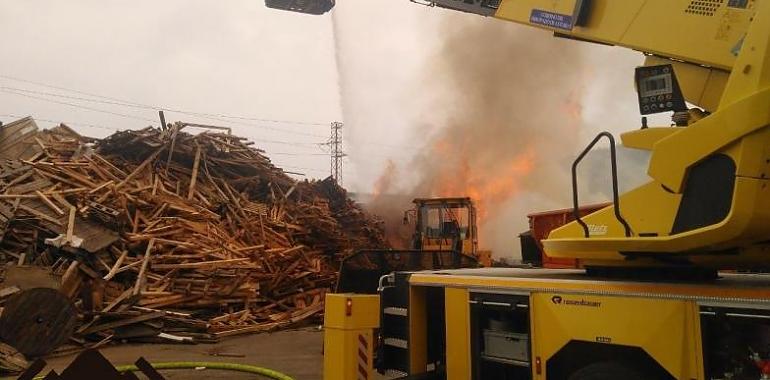 Bomberos de ocho retenes logran sofocar el incendio en una gran masa de palés en Gozón