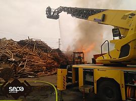 Bomberos de ocho retenes logran sofocar el incendio en una gran masa de palés en Gozón