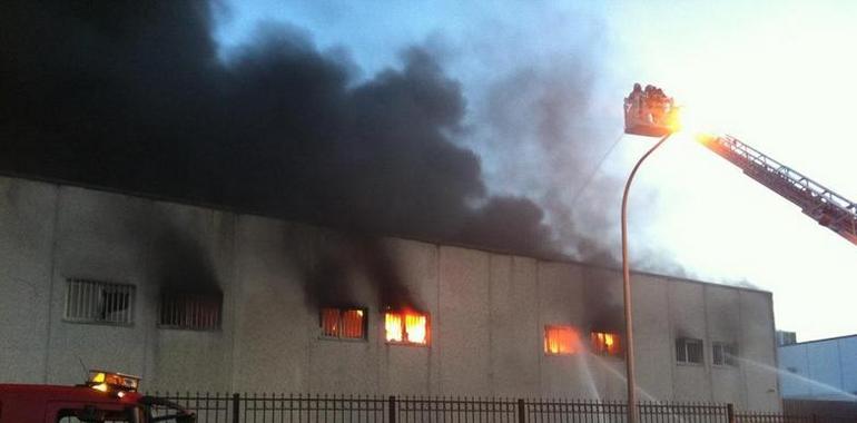 12 dotaciones de bomberos luchan para apagar un voraz incendio en una fábrica de bolsos en Arganda