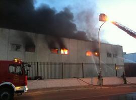 12 dotaciones de bomberos luchan para apagar un voraz incendio en una fábrica de bolsos en Arganda